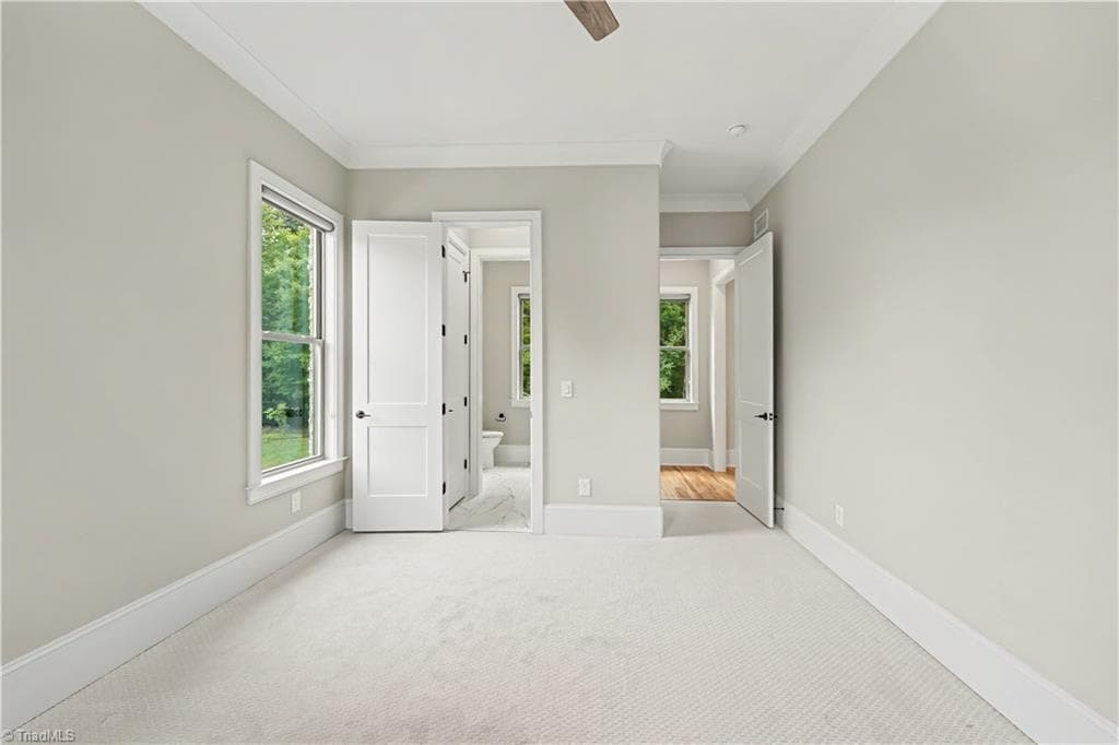 The upstairs full bathroom features sleek tiled shower walls and provides convenient access to the dual-vanity half-baths serving the ensuite bedrooms. - 1477 Cappoquin Way, Burlington NC 27215, Burlington