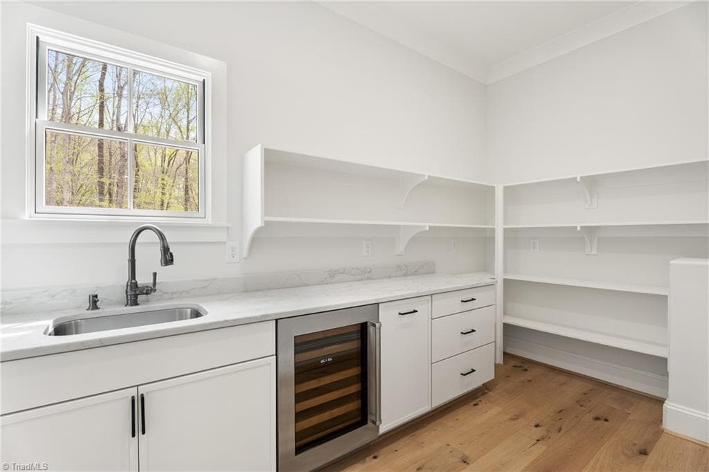 Well-equipped scullery with prep sink, beverage fridge, open shelving, and abundant storage. - 9664 Lissara Camp Court, Lewisville NC 27023, Lewisville