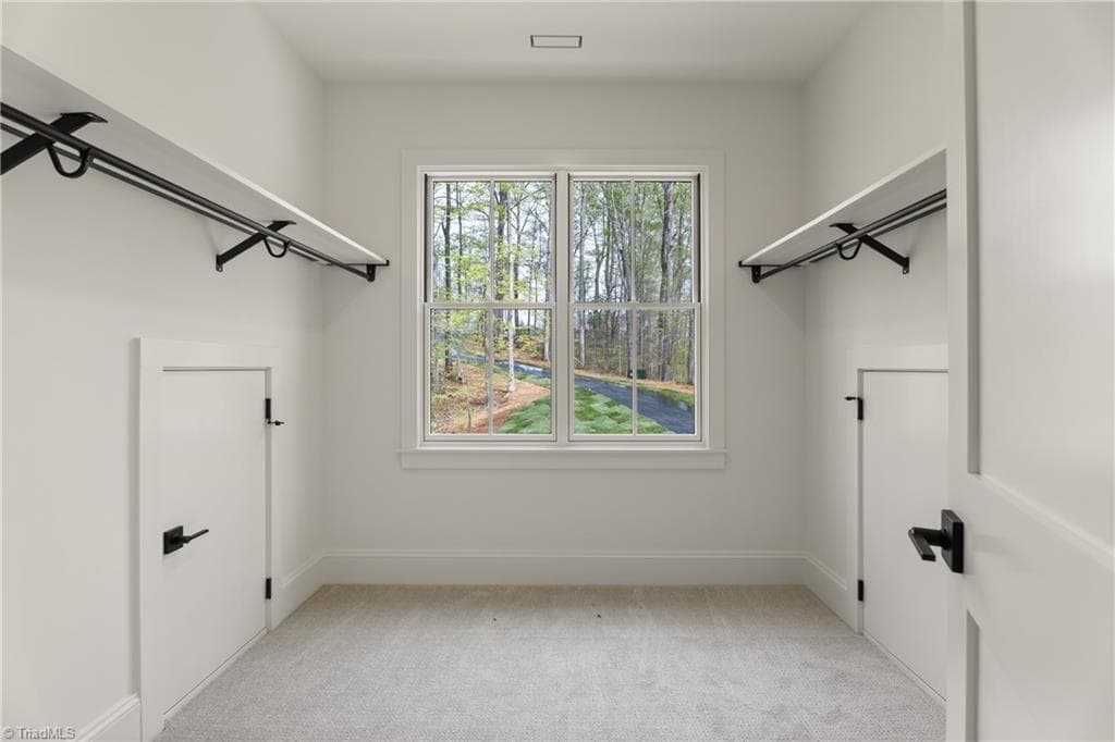 Walk-in closet with excellent storage and a window bringing in natural light. - 9664 Lissara Camp Court, Lewisville NC 27023, Lewisville