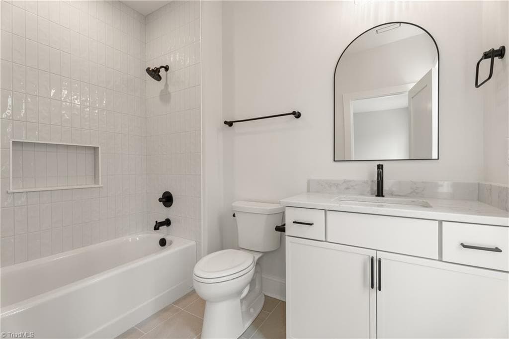 Ensuite bath with tiled tub surround, modern fixtures, and a beautifully finished vanity. - 9664 Lissara Camp Court, Lewisville NC 27023, Lewisville