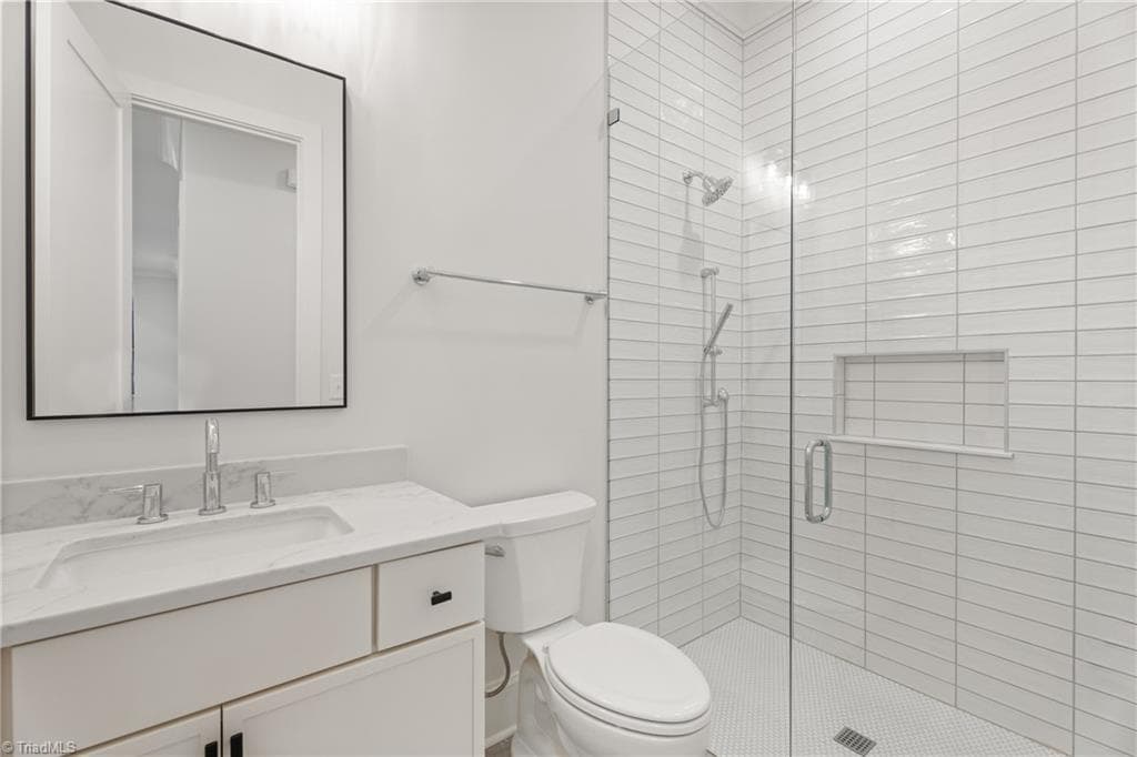 Well-appointed secondary bath with tiled shower and clean, timeless finishes. - 9664 Lissara Camp Court, Lewisville NC 27023, Lewisville