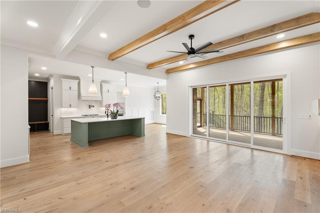 Large sliding doors frame the wooded backdrop and fill the main living area with natural light. - 9664 Lissara Camp Court, Lewisville NC 27023, Lewisville