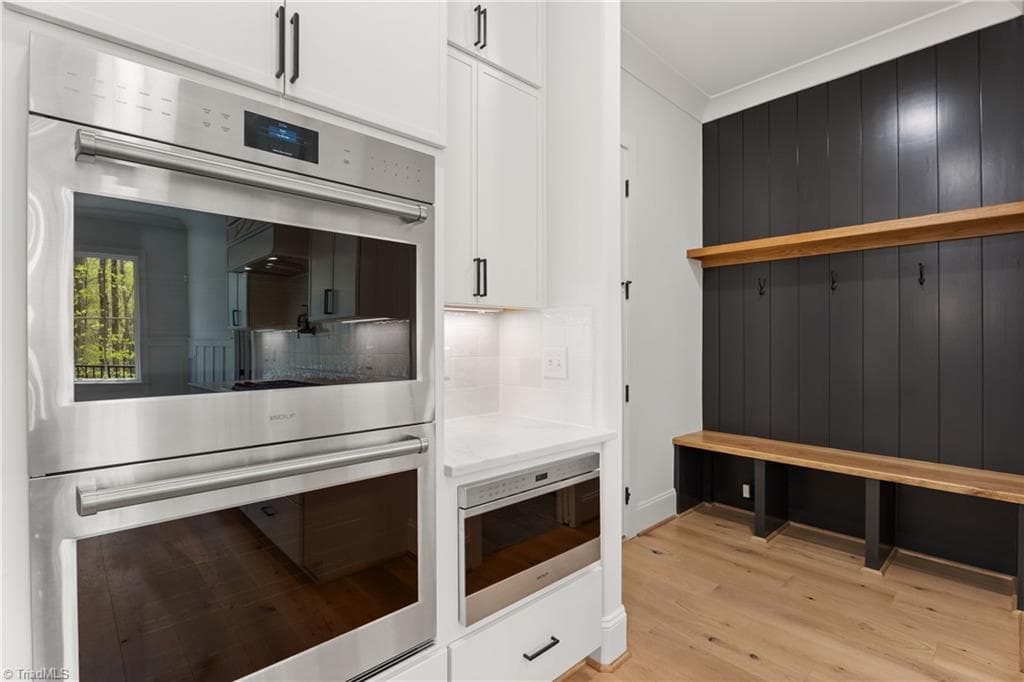 Built-in double ovens and a drop zone with bench seating add function to the heart of the home. - 9664 Lissara Camp Court, Lewisville NC 27023, Lewisville