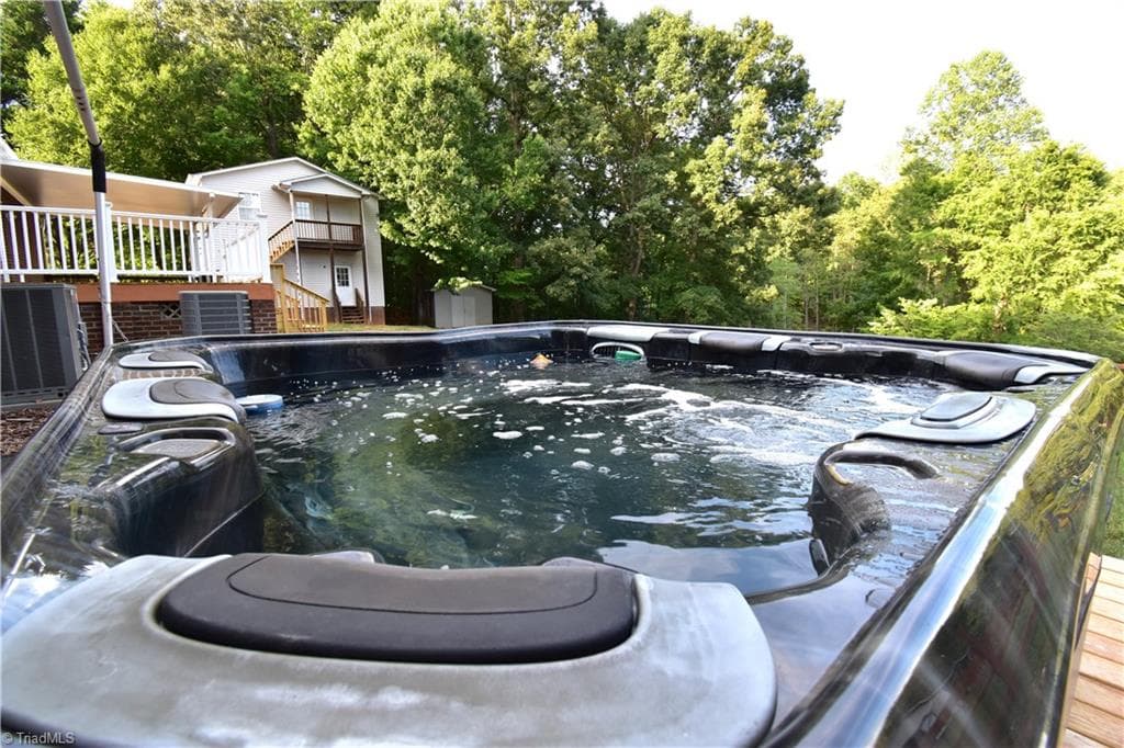 The hot tub features views of the back yard, pond and the barn with your 4 legged friends. - 8546 Hudson-James Road, Summerfield NC 27358, Summerfield