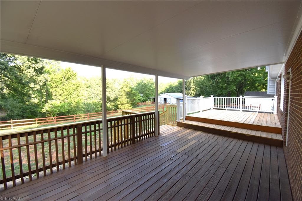 The large covered porch has a commanding view of the pond and barn. - 8546 Hudson-James Road, Summerfield NC 27358, Summerfield