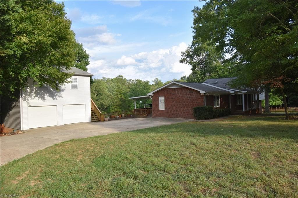 The front of the home is bathed in afternoon and evening shade. This is one of two parking areas. - 8546 Hudson-James Road, Summerfield NC 27358, Summerfield