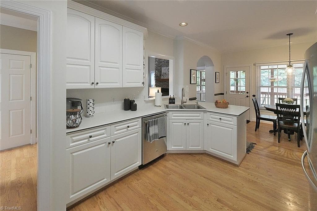 Pristine kitchen featuring a convenient pass-through to the family room, highlighted by an elegant archway and a sophisticated stone fireplace. - 1101 Clyde Edgerton Drive, Kernersville NC 27284, Kernersville