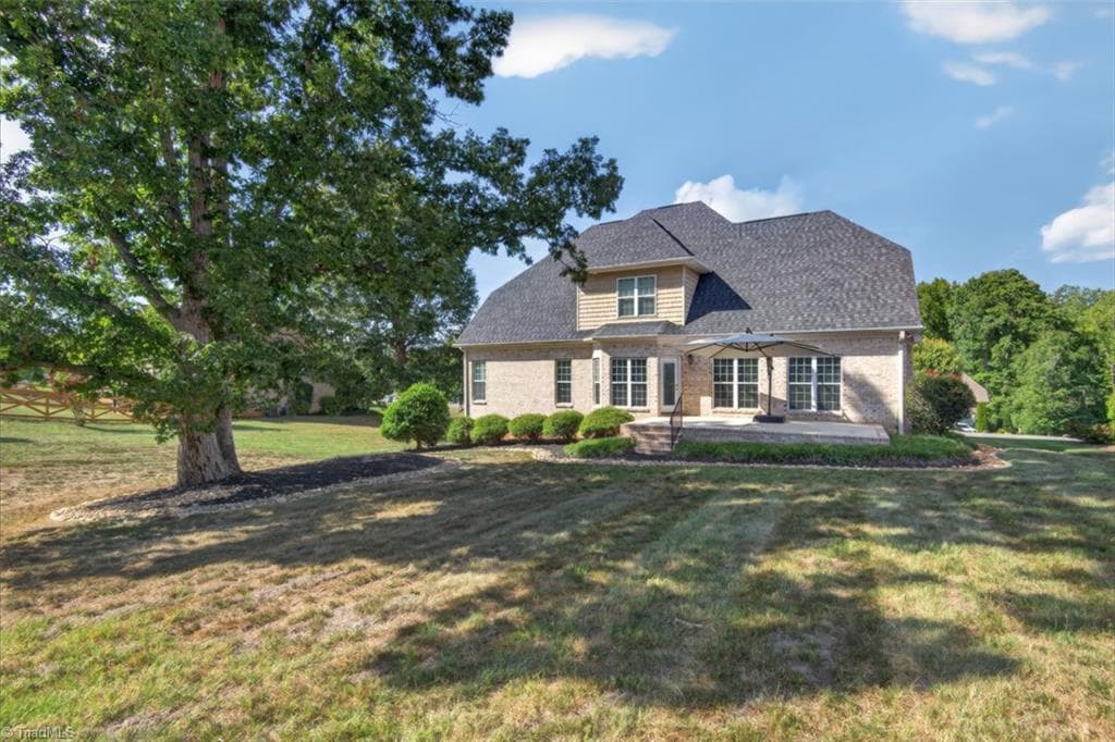 The spacious backyard offers a peaceful retreat, featuring a generous patio, mature shade tree, and plenty of room to relax, entertain, and enjoy the tranquil setting. - 7807 Winterbourne Drive, Summerfield NC 27358, Summerfield