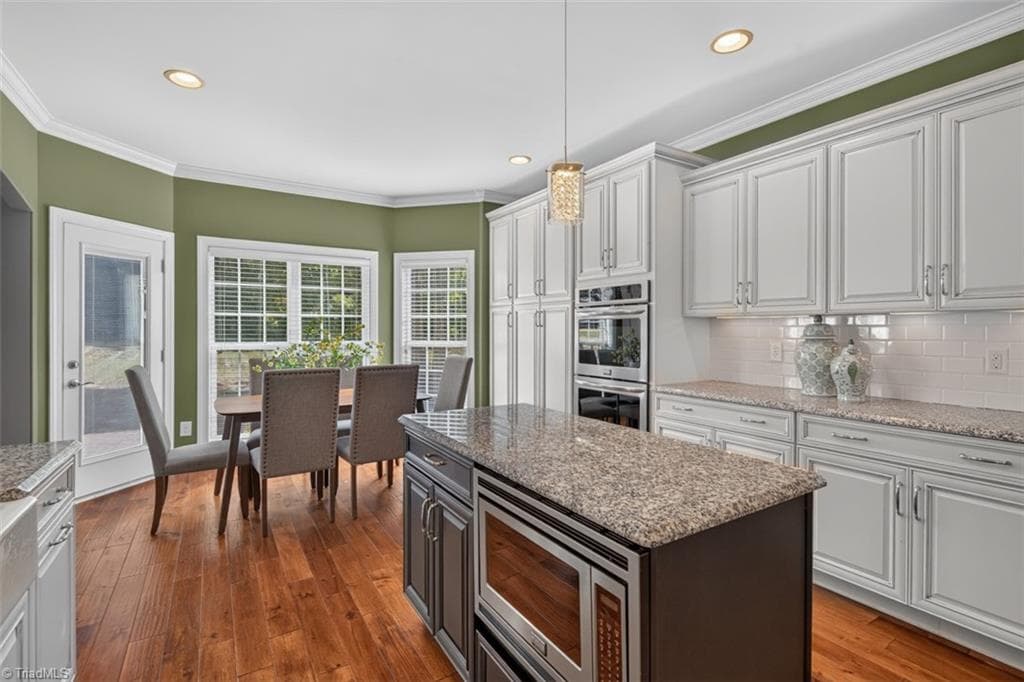 Tucked away microwave in the kitchen island w/storage. - 7807 Winterbourne Drive, Summerfield NC 27358, Summerfield