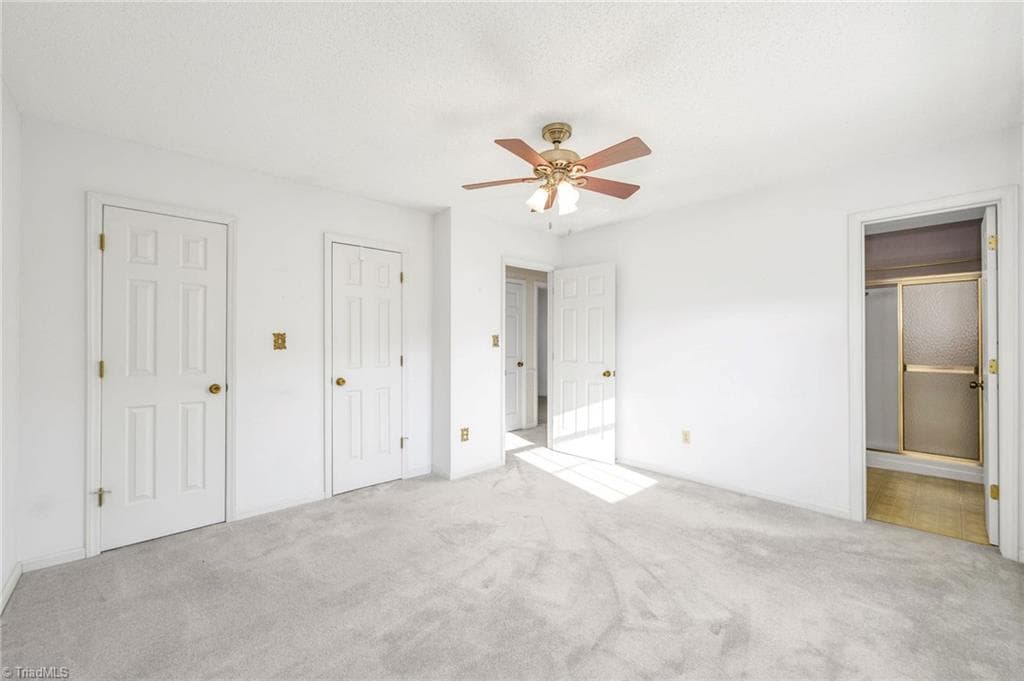 Primary Bedroom with double lighted closets and attached bath with shower. - 196 Lewis Fork Drive, Wilkesboro NC 28697, Wilkesboro