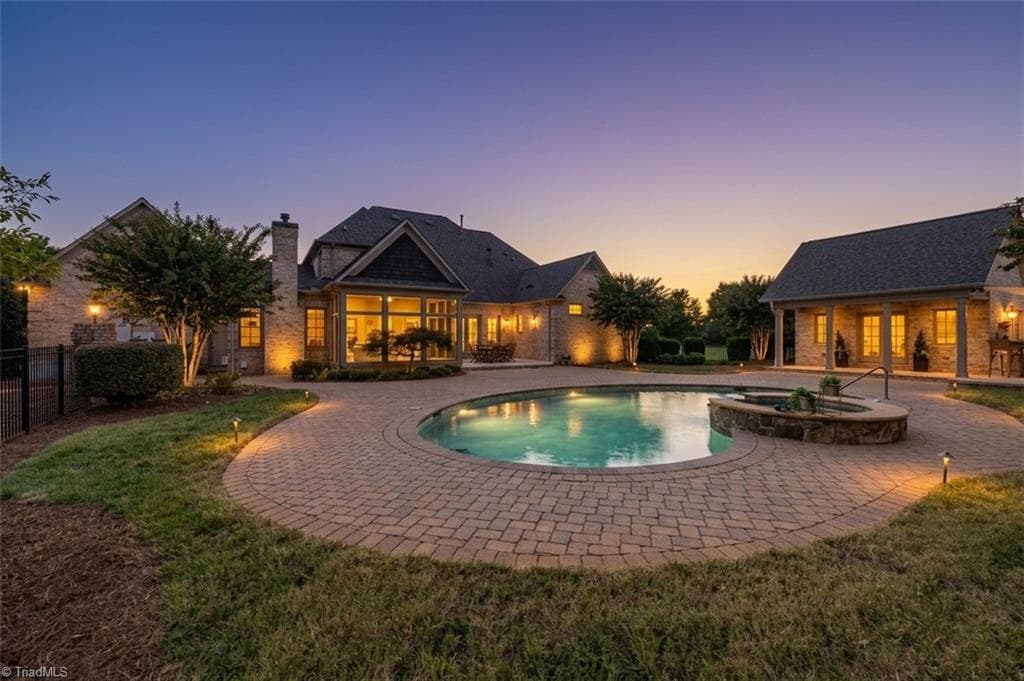 Picture warmer evenings here! A gorgeous paver patio surrounds an inground pool and hot tub. A convenient heated and cooled pool house with kitchenette and 1/2 bath. - 7404 Hadleigh Court, Oak Ridge NC 27310, Oak Ridge