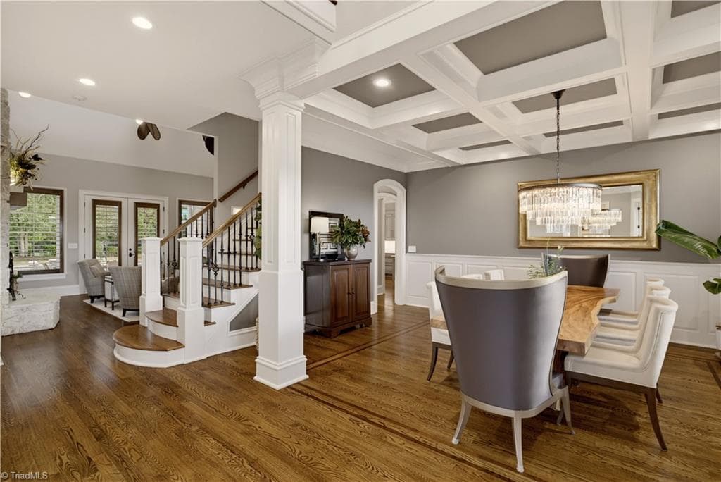 Step inside and you'll fee it right away! View from the 2 story foyer into dining room with coffered ceiling and 2 story living room area. Stunning hardwoods and unique fixtures throughout! - 7404 Hadleigh Court, Oak Ridge NC 27310, Oak Ridge