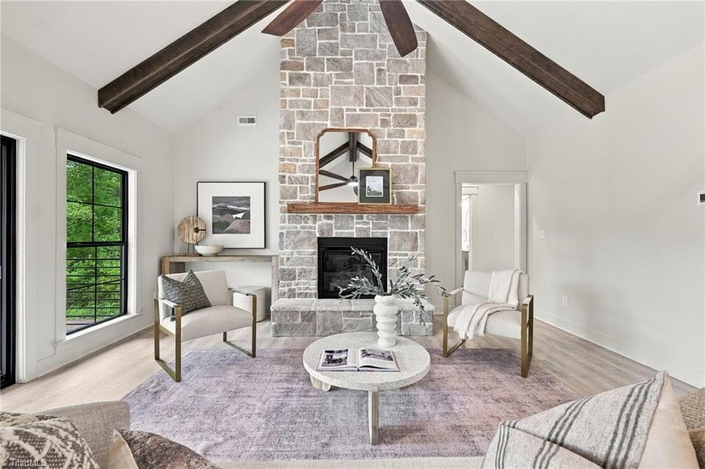 Dramatic Floor-to-Ceiling custom stone fireplace framed by rich ceiling beams, creates a warm inviting focal point. - 224 Pearson Farm Road, Summerfield NC 27358, Summerfield