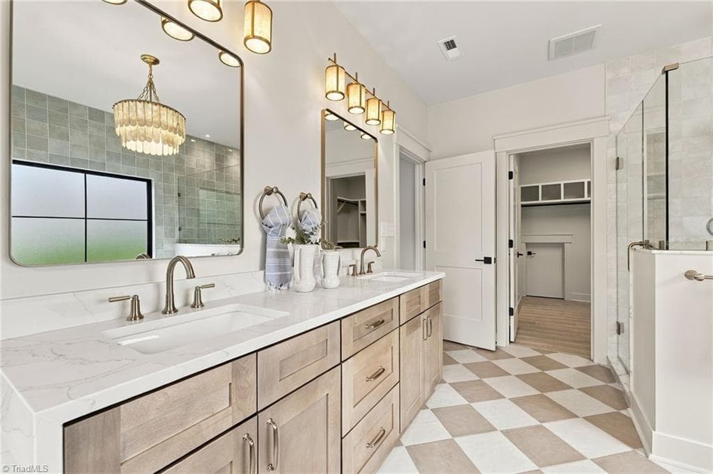 The exquisite custom vanity is beautifully finished with gorgeous Lighting. - 224 Pearson Farm Road, Summerfield NC 27358, Summerfield