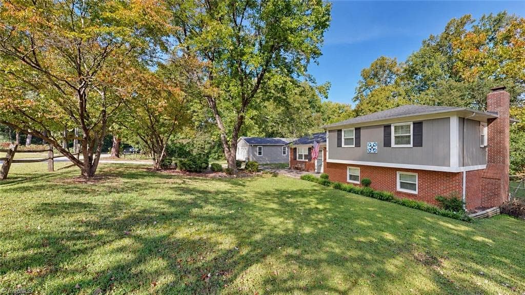 View from the side of the home again shows nice landscaping and that it has a really nice yard little over an acre per tax card - 1823 Bantry Trail, Kernersville NC 27284, Kernersville