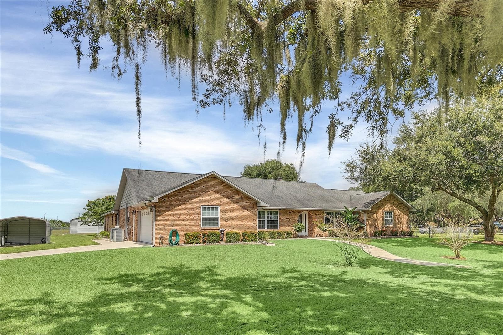 Side Garage with 12x20 Carport on the left. - 4147 BOGGY CREEK RD, KISSIMMEE