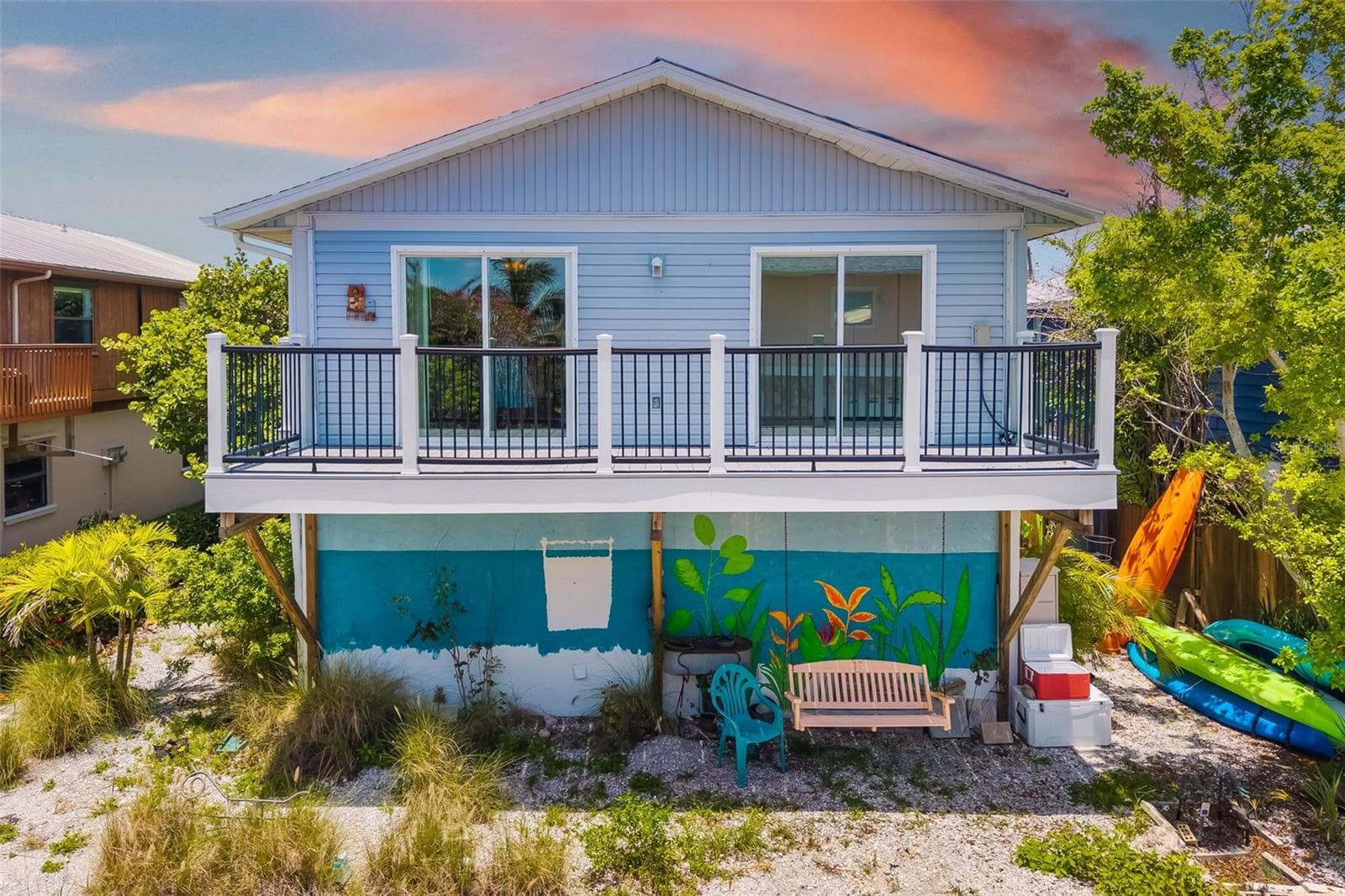 Rear Exterior (Twilight Feel)Elevated home with spacious deck and inviting outdoor living areas—perfect for enjoying island evenings. - 2513 AVENUE B #B, BRADENTON BEACH