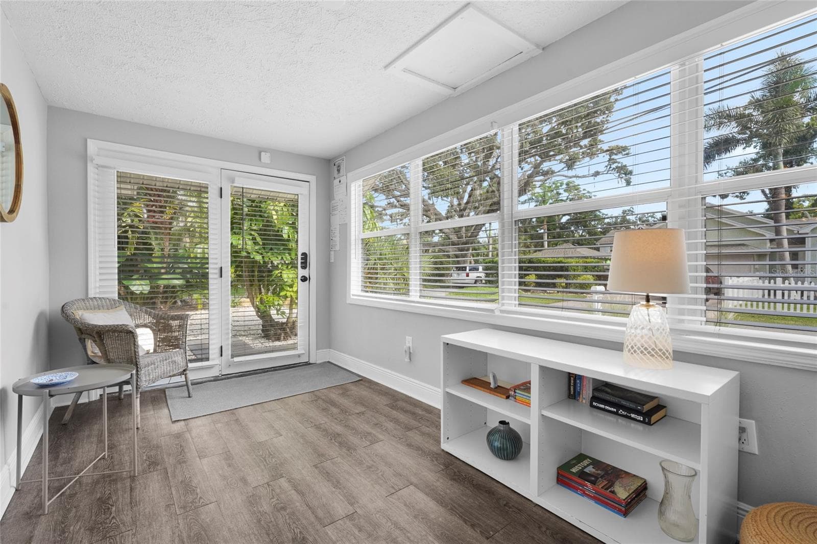 Bright and Airy Entry – Step into a sun-drenched Florida room featuring luxury vinyl flooring and a wall of windows—ideal as a reading nook, guest landing zone, or flex workspace. - 2705 2ND AVE W, BRADENTON