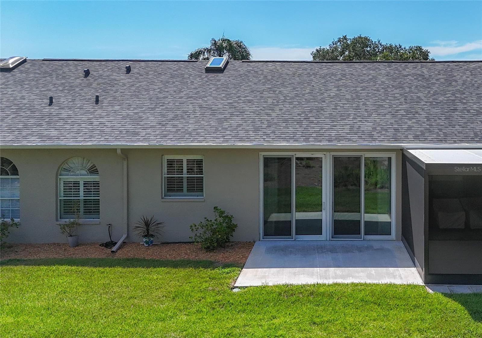Back of villa includes large concrete patio to enjoy the beautiful view of the 8th tee of the golf course - 6948 STONEYWALK CT, BRADENTON