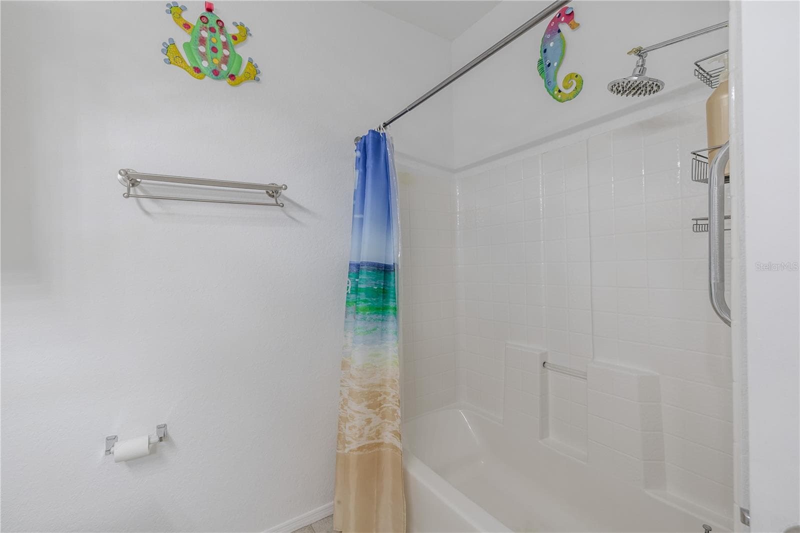 This clean and well-appointed tub/shower combination features crisp white tile surround, built-in shelving, updated fixtures, and a bright, beach-inspired aesthetic that complements the home’s coastal feel. - 2738 VIA TIVOLI #220B, CLEARWATER