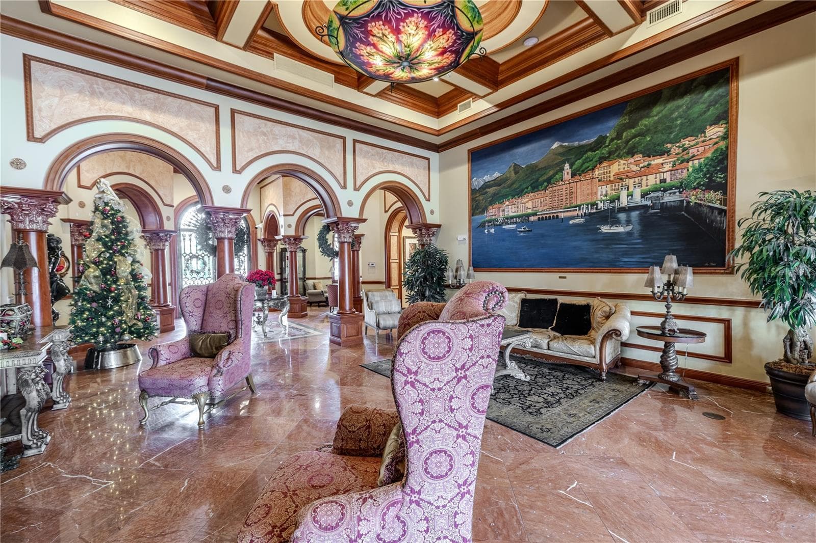 Another view of the grand clubhouse lounge with soaring coffered ceilings, dramatic murals and arched columns, gleaming marble floors, and an elegant fireplace seating area that creates a truly resort-style welcome. - 2738 VIA TIVOLI #220B, CLEARWATER