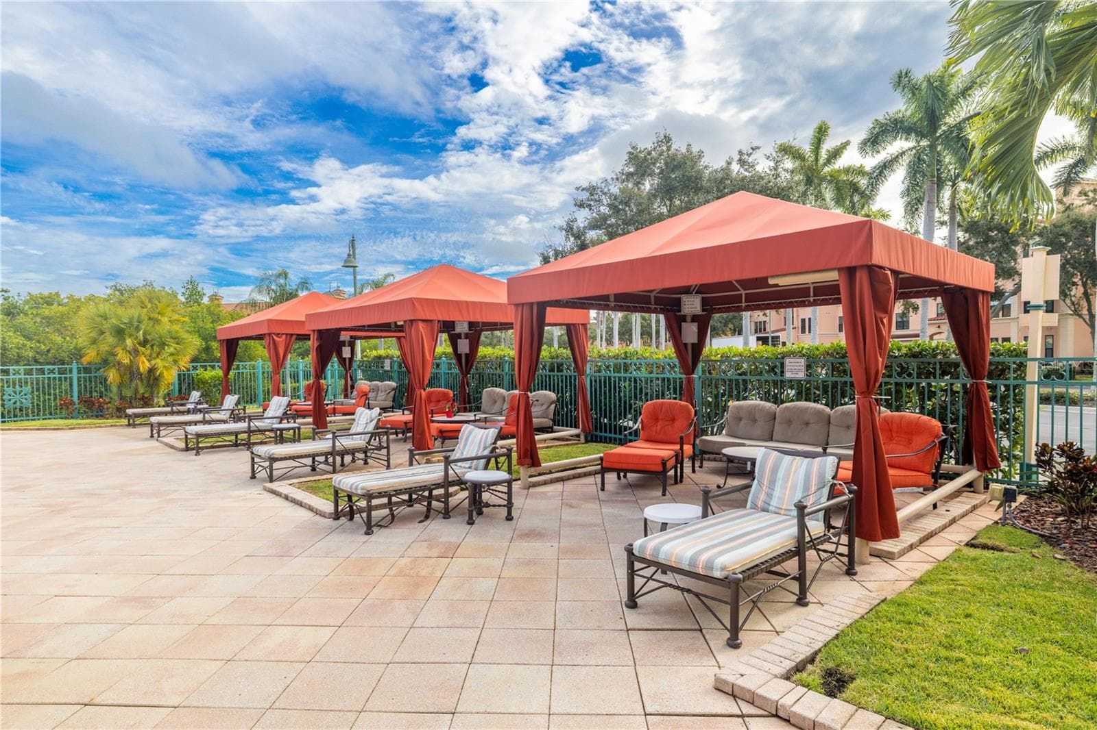 Private poolside cabanas with comfortable lounge seating, perfect for relaxing in the shade and enjoying a true resort-style community atmosphere. - 2738 VIA TIVOLI #220B, CLEARWATER
