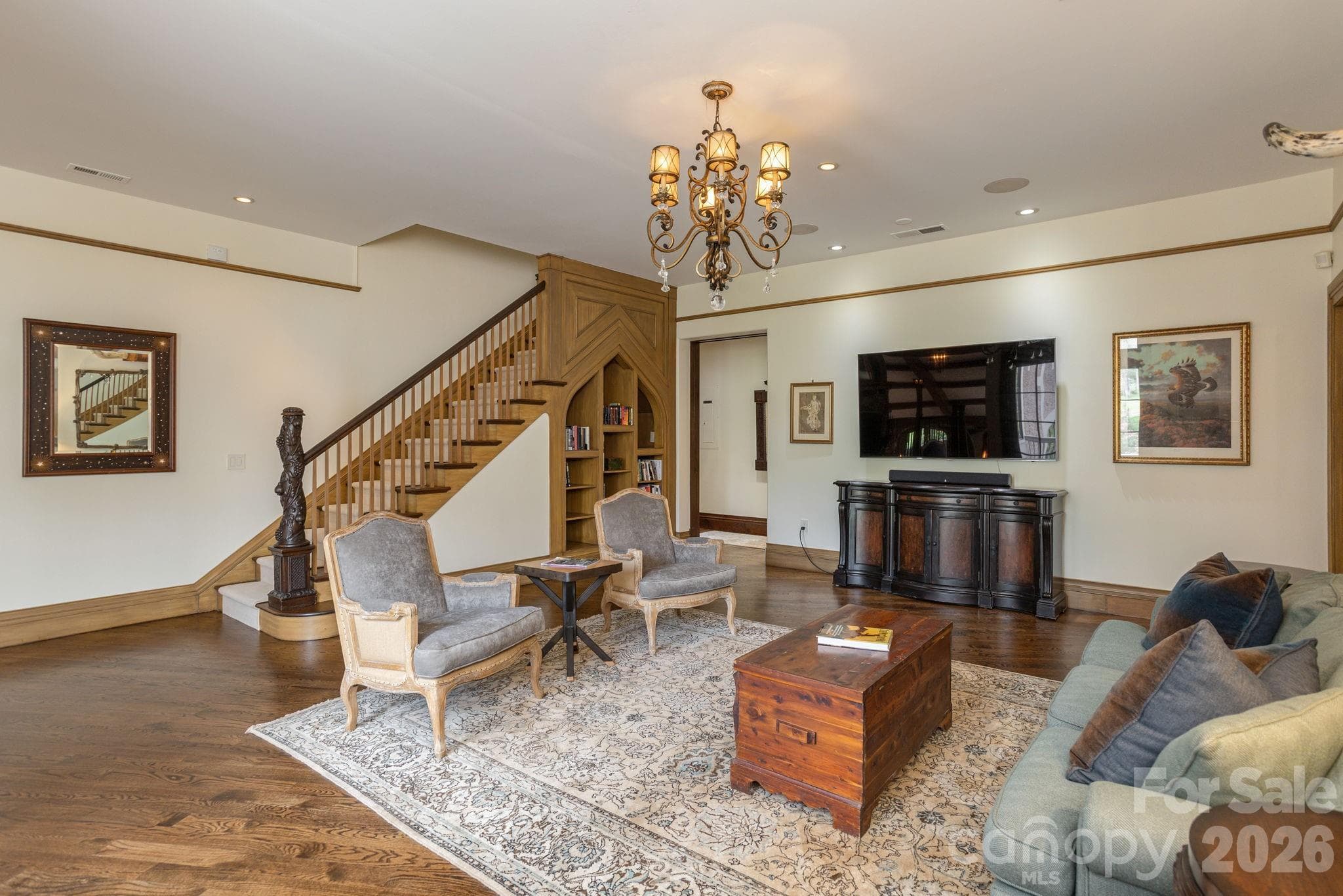 Spectacular living room with custom millwork, elegant hardwood floors, built-in shelving and a dramatic staircase. - 8 Fairway Place, Asheville