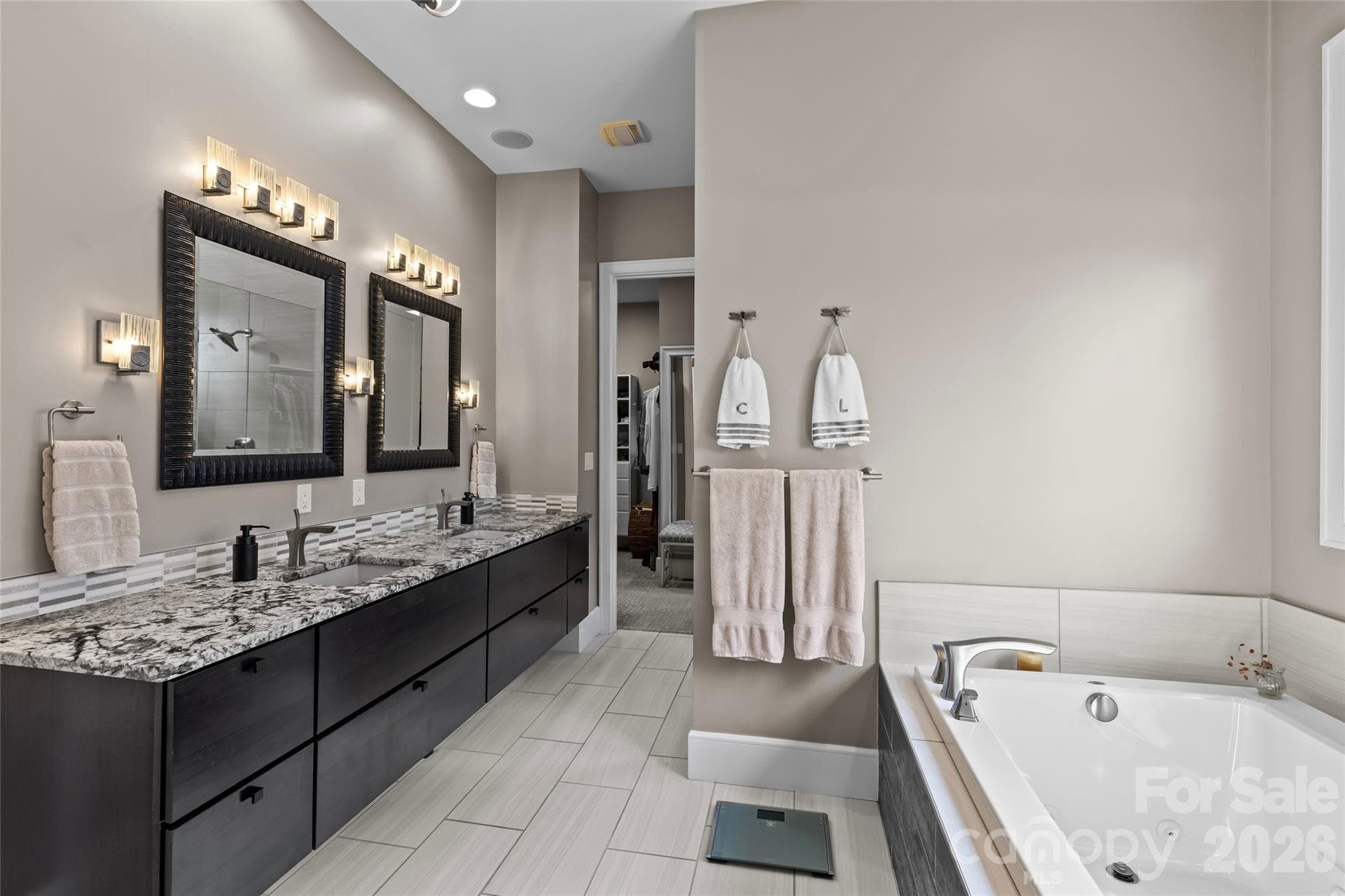 Primary suite has stunning lake views, gas fireplace, sitting area/office, double vanity, shower, bathtub, water closet & walk-in closet with access to the laundry room. - 6032 Headlands Court, Belmont