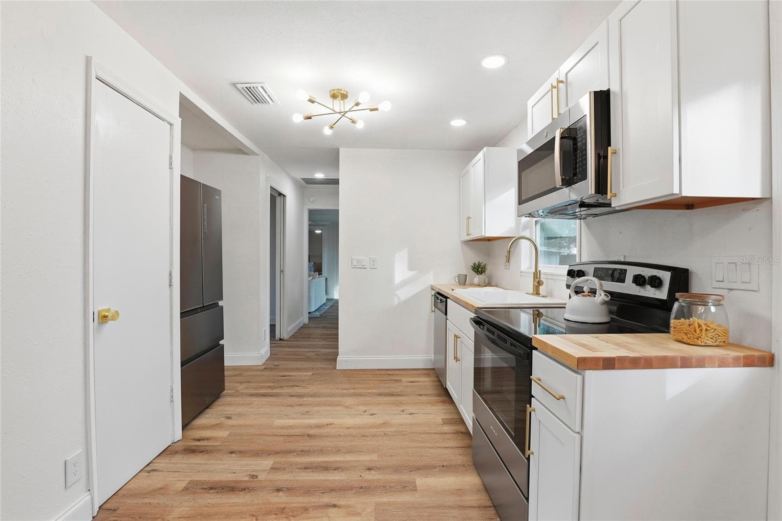 New kitchen with white shaker cabinets, stainless range and microwave - 425 SE 2ND ST, WILLISTON