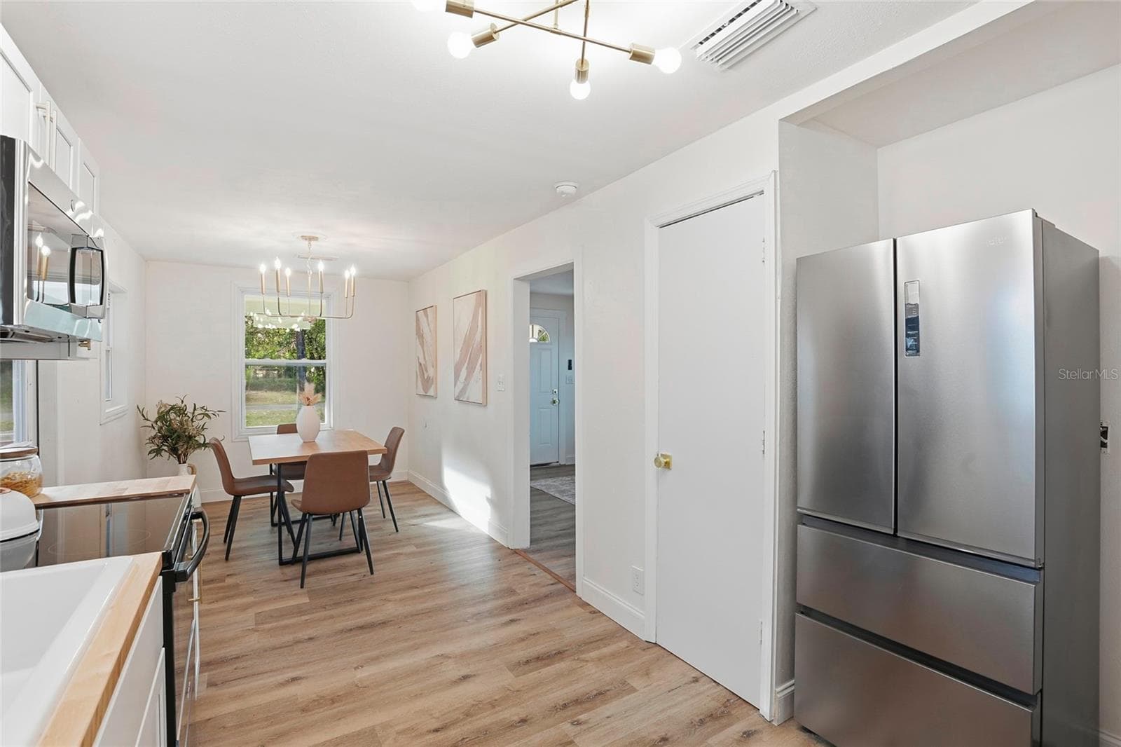 Kitchen with new stainless refrigerator and modern lighting - 425 SE 2ND ST, WILLISTON