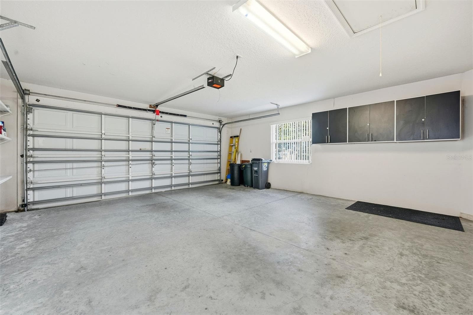 2-car garage with extra storage cabinets, shelving and pull down stairs for attic access - 2311 N ANDREA PT, LECANTO