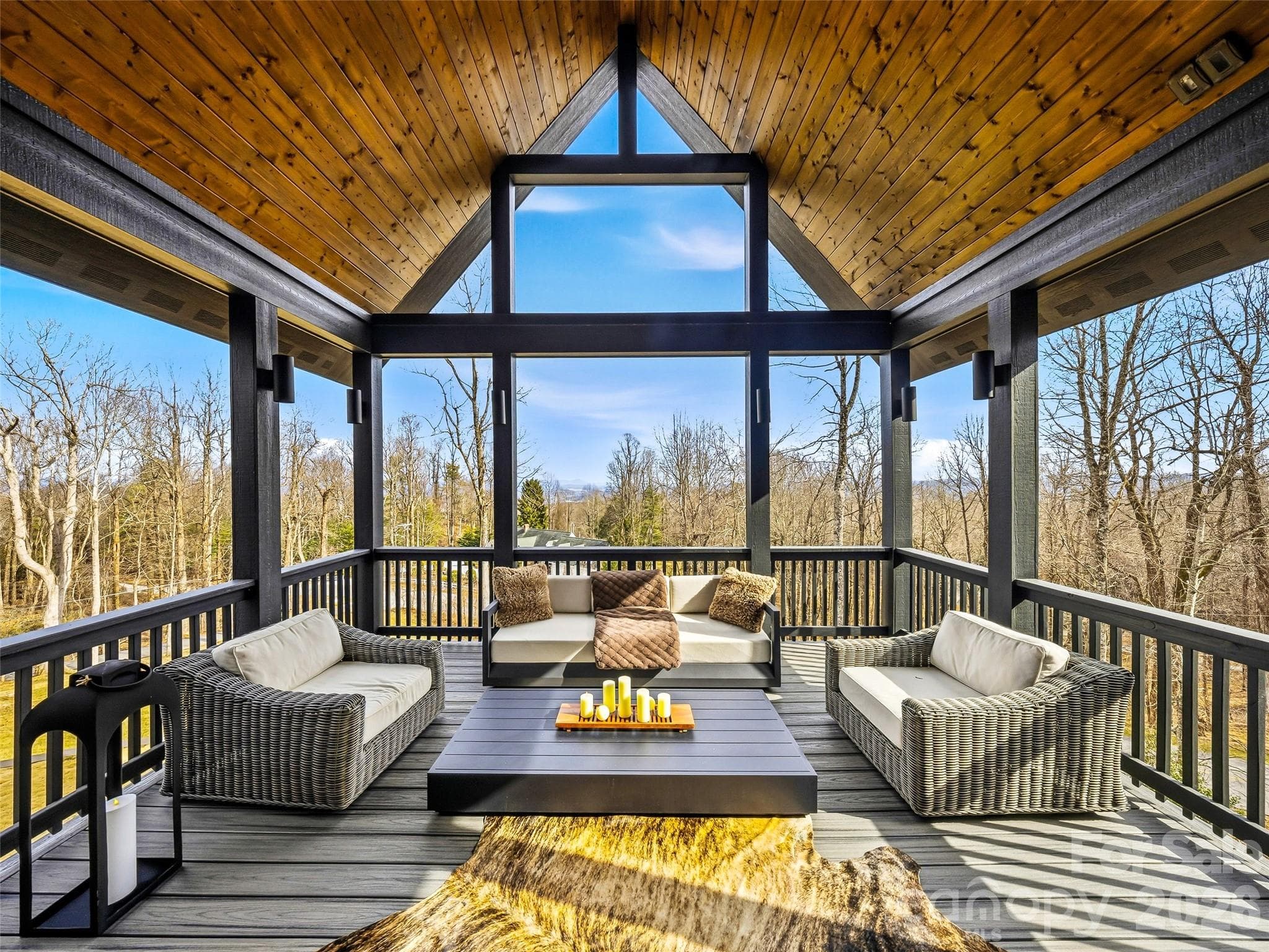 Covered deck with vaulted wood ceiling and expansive windows capturing serene views - 241 Tower Circle, Hendersonville