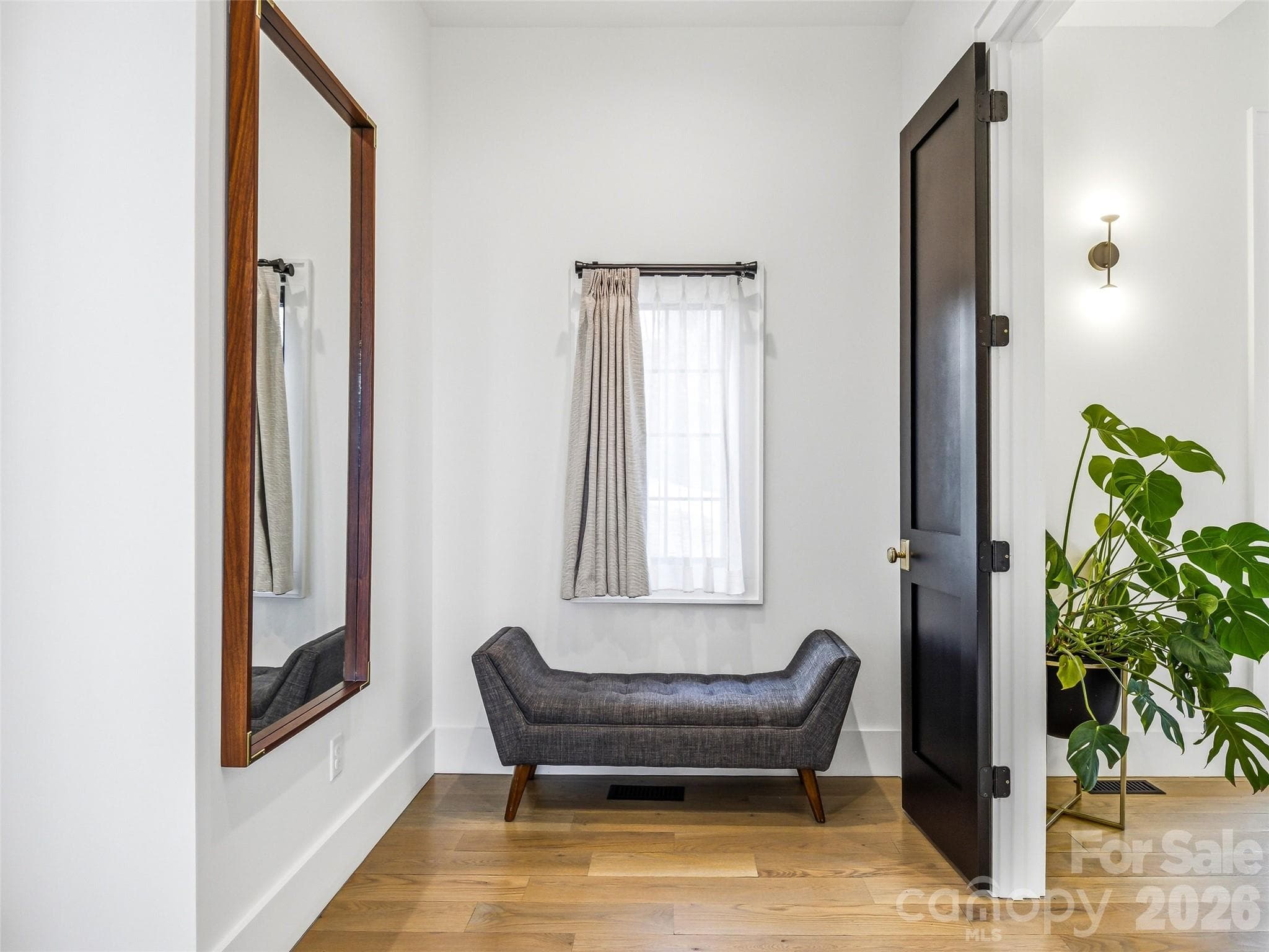 A welcoming foyer-style entry to the primary suite offers hardwood floors, soft natural light, and space for a sitting area - 241 Tower Circle, Hendersonville