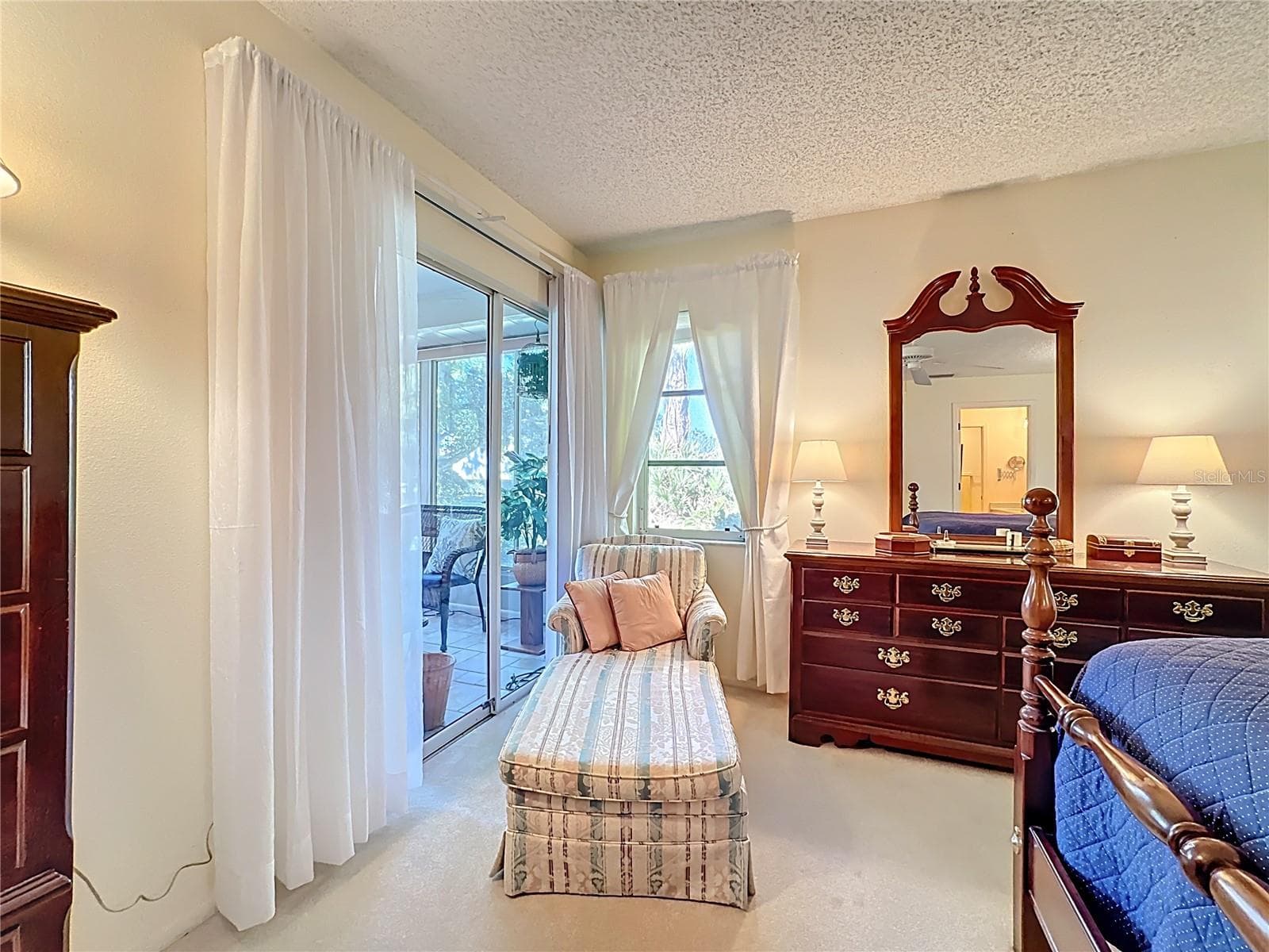 Primary bedroom with sliding door to the Florida room. - 5611 GARDEN LAKES DR, BRADENTON