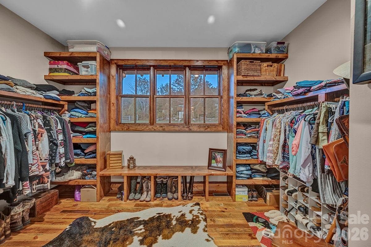 One of two large primary closets with wood shelving and bench - 217 Sunrise Vista Lane, Banner Elk