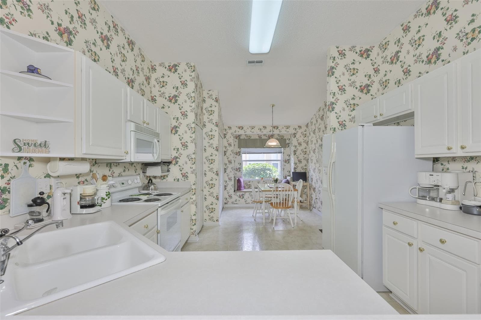 LIGHT AND BRIGHT KITCHEN LOOKING INTO THE BREAKFAST NOOK WITH THE BIG WINDOW. - 2308 BROOKFIELD GREENS CIR, SUN CITY CENTER