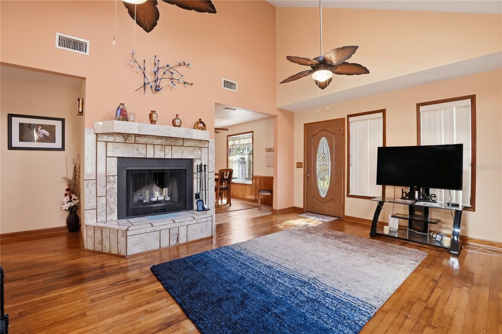 Living room with high ceiling, sky lights, real wood floors and beautiful wood-burning fireplace. - 3131 JUNIPER DR, EDGEWATER