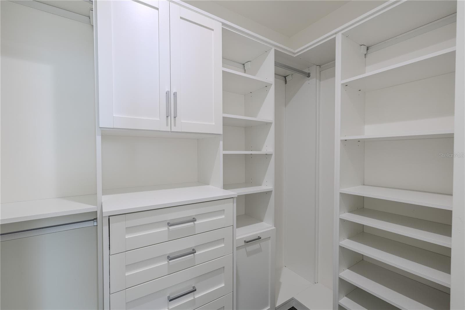 Bedroom 3 walk-in closet is thoughtfully designed with built-in shelving, drawers, and hanging space, providing both beauty and function. Soft-close cabinetry, modern hardware, and ample storage make organization effortless. - 920 N OSCEOLA AVE #703, CLEARWATER