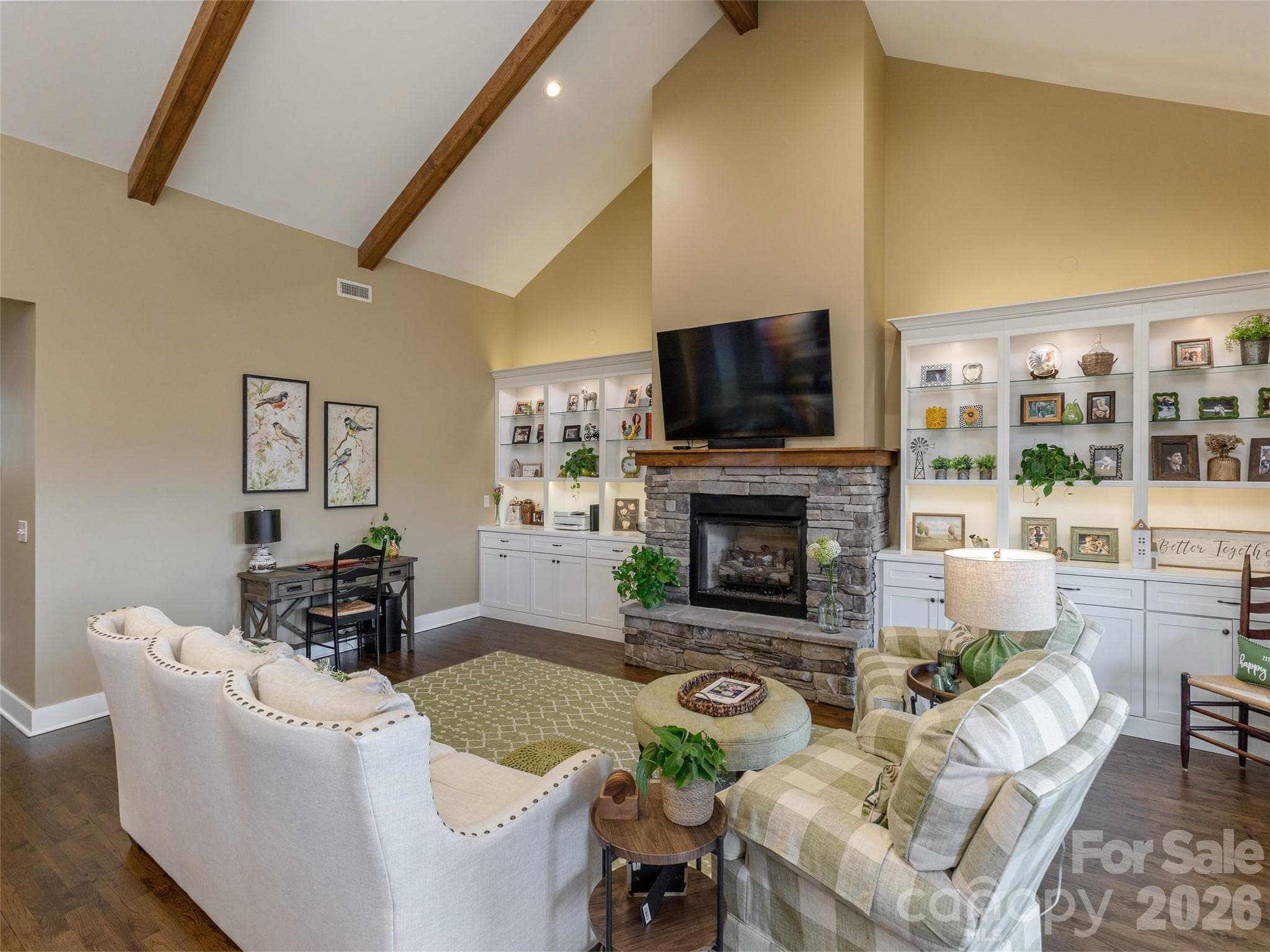 Custom bookcases and shelving are accented with recessed lighting, creating an elevated, sophisticated look. A pull-out desk provides streamlined efficiency, offering a functional workspace that tucks away seamlessly when not in use. - Hendersonville