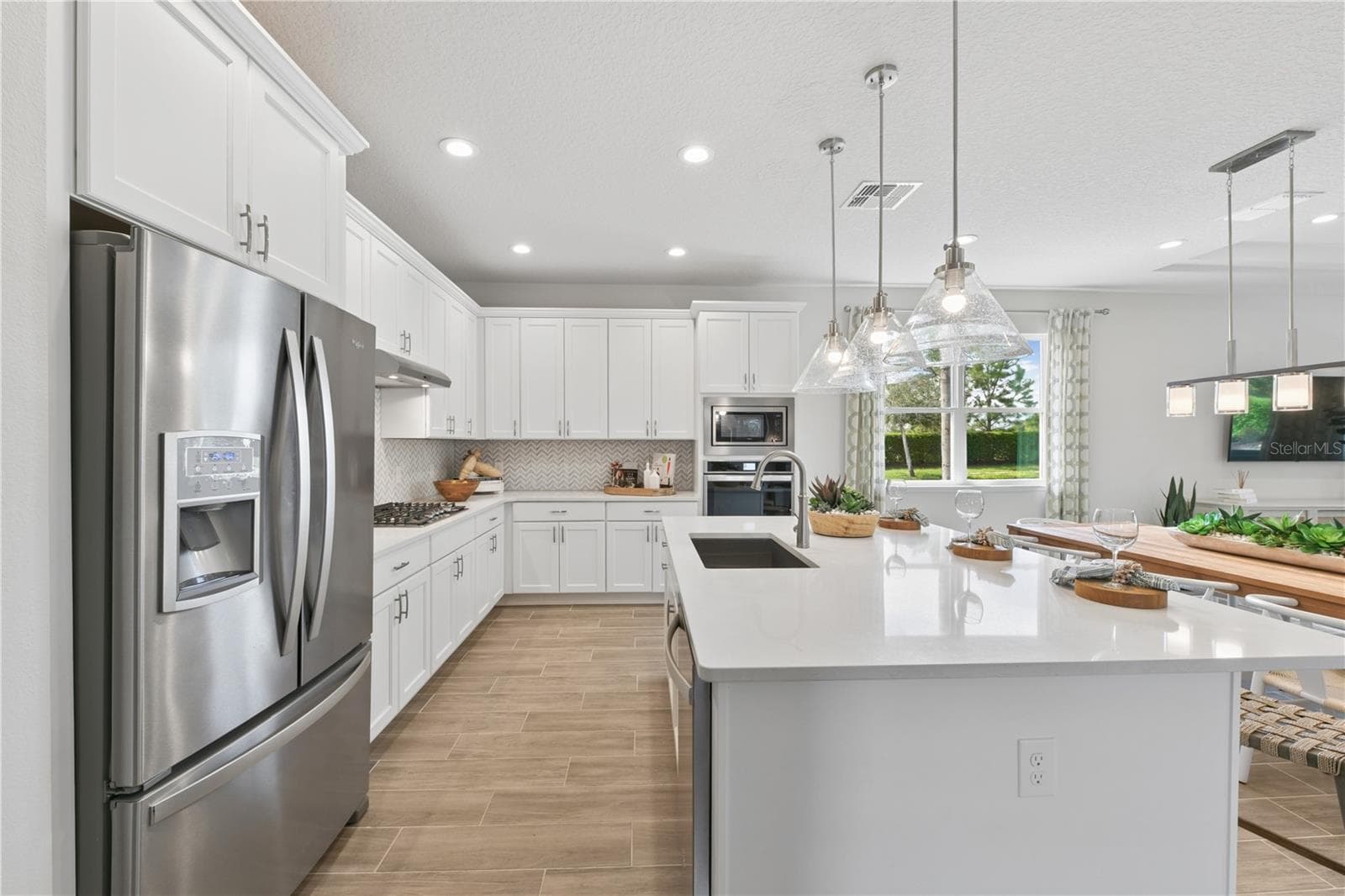 Bright gourmet kitchen with crisp finishes, light cabinetry, and natural textures for an effortless, airy feel. - 2418 PARK RIDGE ST, APOPKA