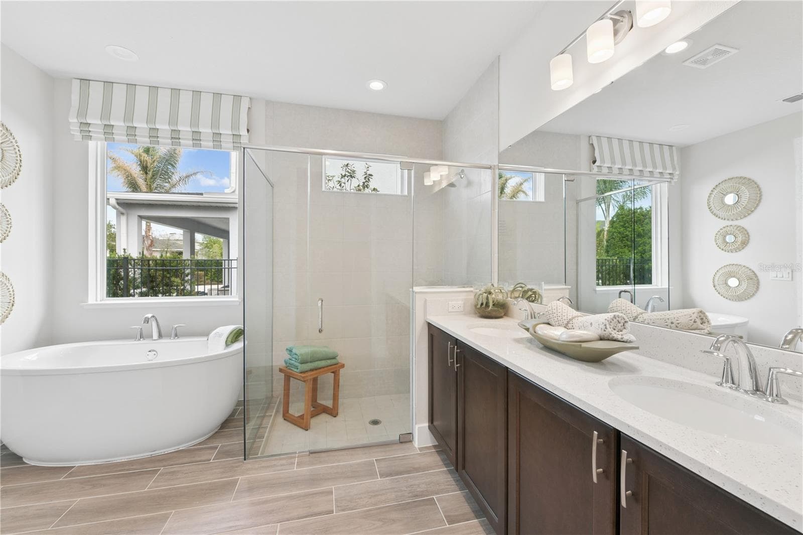 Spacious primary suite with soft, calming tones and a luxurious ensuite featuring a freestanding tub, walk-in shower, dual vanities, and walk-in closet. - 2418 PARK RIDGE ST, APOPKA