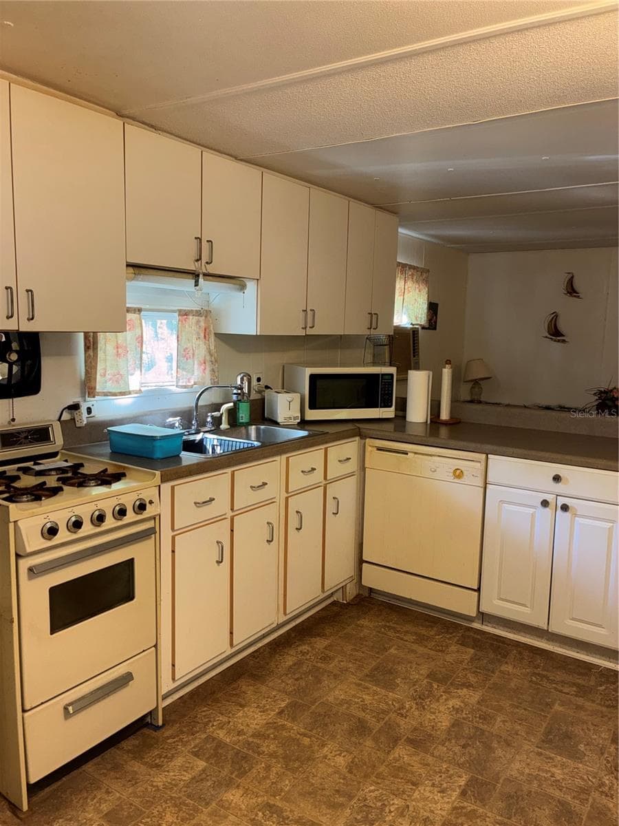 View of kitchen from the living room. - 24533 PINK PANTHER RD, PAISLEY