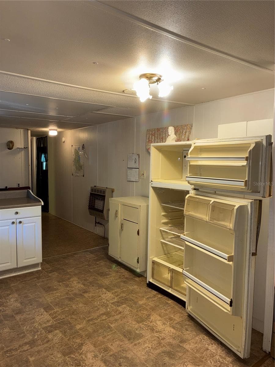 View from kitchen past dining to a bedroom and full bathroom. Door to storage shed and laundry is also off this hallway. - 24533 PINK PANTHER RD, PAISLEY