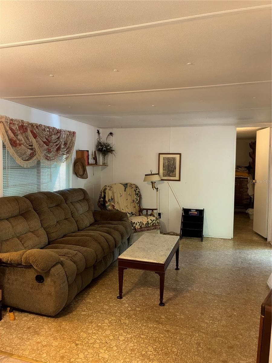 Looking into the living room from the kitchen. Second bedroom and half bath is through the door on the right. - 24533 PINK PANTHER RD, PAISLEY
