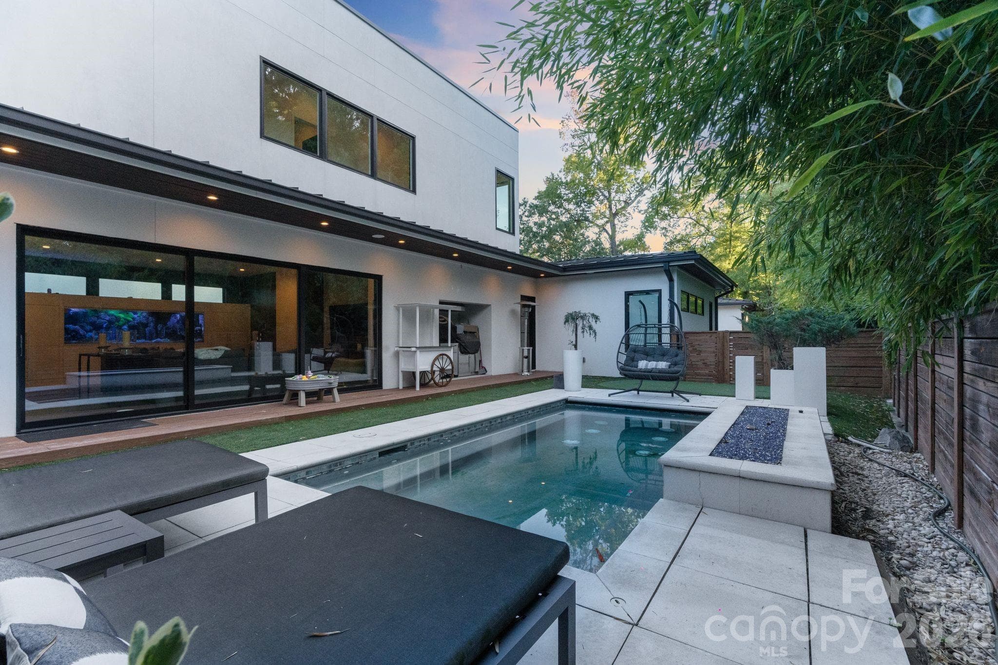 Heated pool with fire pit and extended view of great room and kitchen. - Charlotte