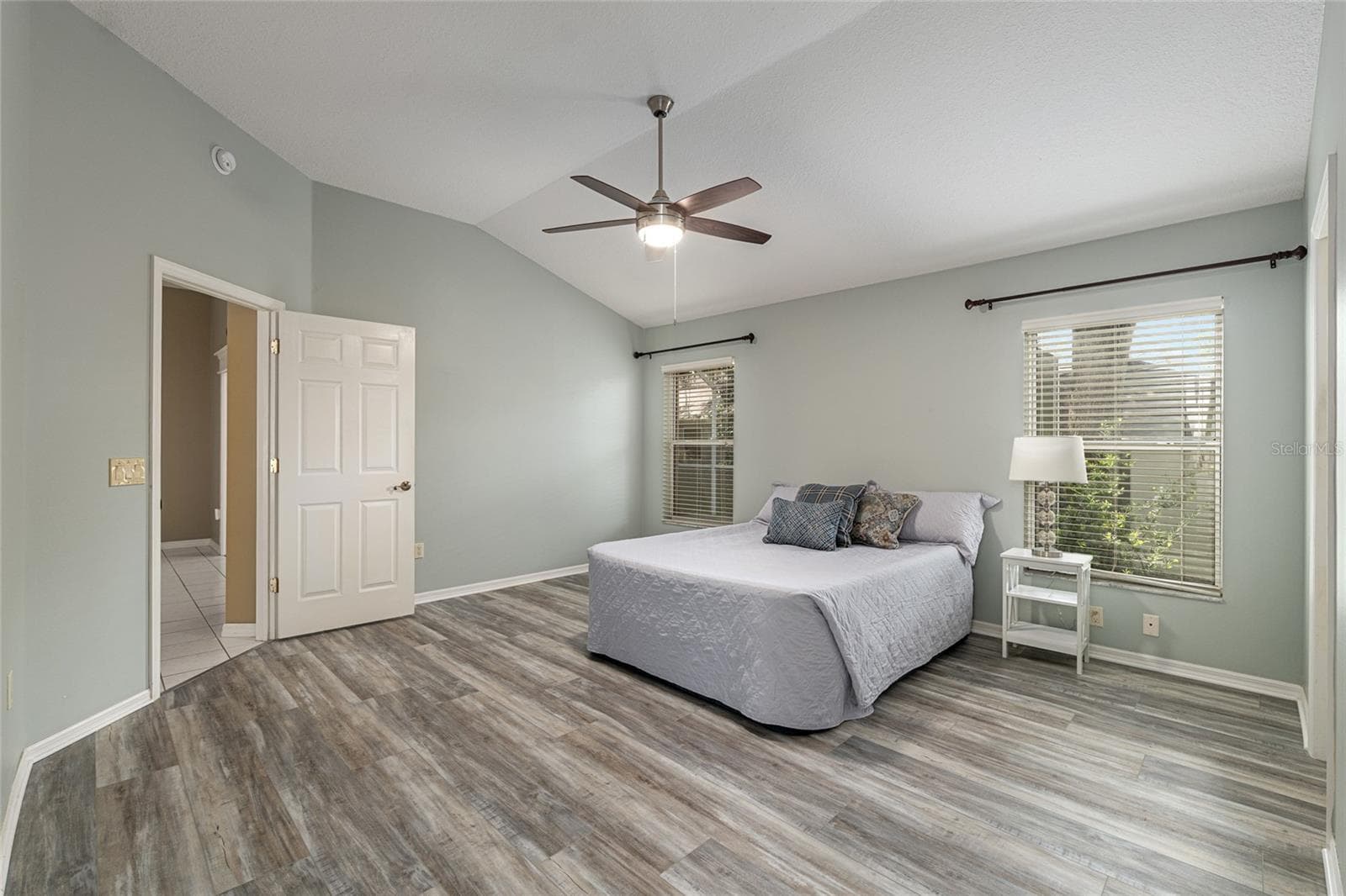 Primary Bedroom (Alternate View): Generous layout with multiple windows allows for abundant natural light and flexible furniture placement. - 110 CHULA VISTA AVE, LADY LAKE