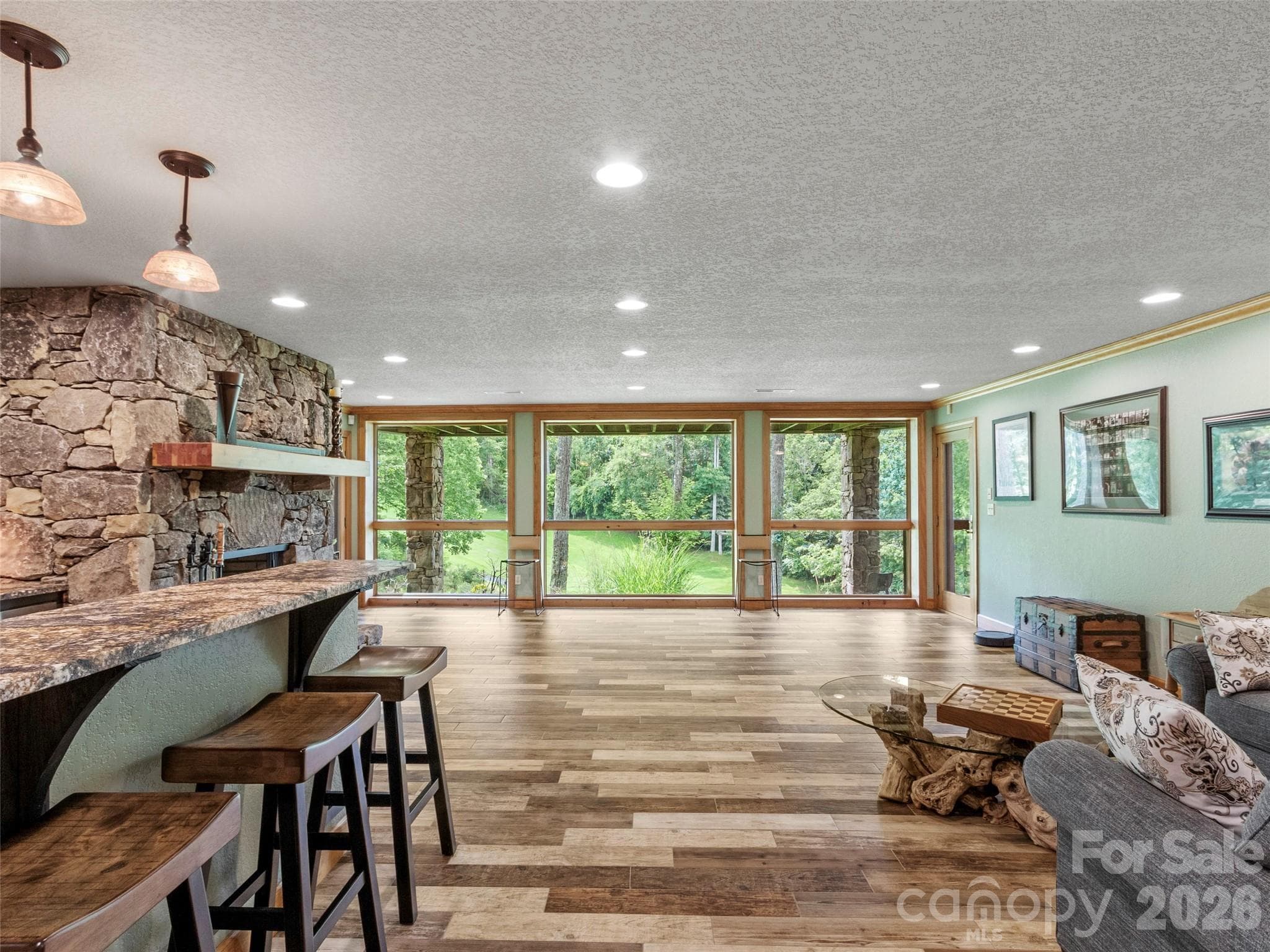 Versatile living space featuring stone fireplace and abundant natural light - 151 Austin Mountain Drive, Burnsville