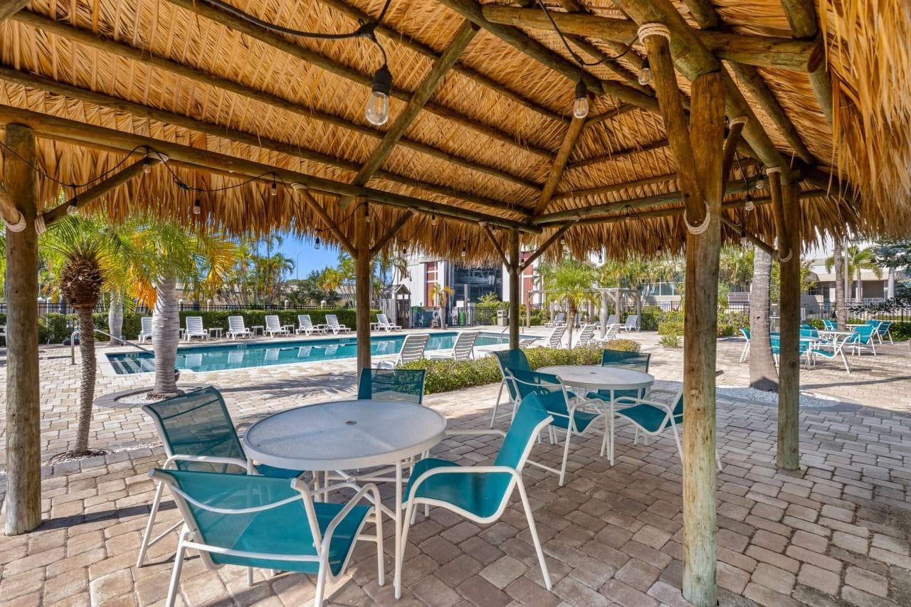 Shaded Tiki seating area next to the pool. - 6057 MOORINGS DR S, ST PETERSBURG