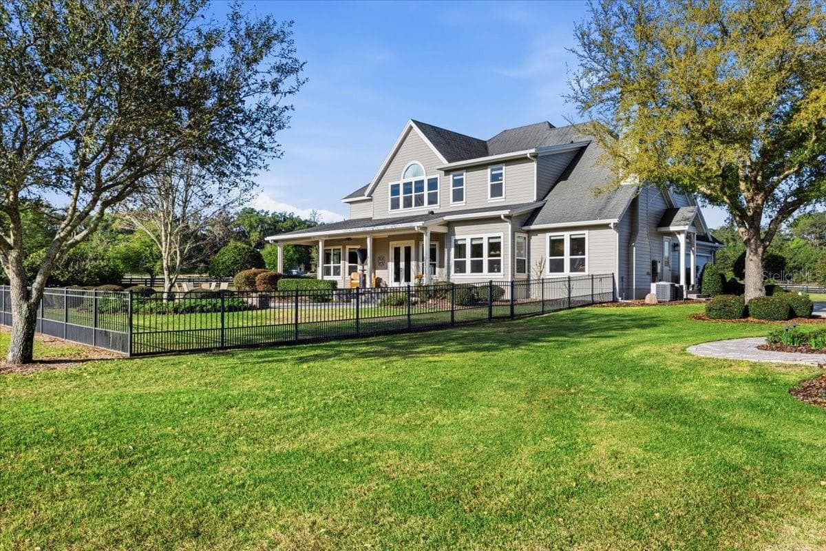 The perimeter of the property is fully-fenced with wood fencing and the backyard of the main home is fenced with beautiful black aluminum fencing. - 10401 NW 153RD TER, ALACHUA