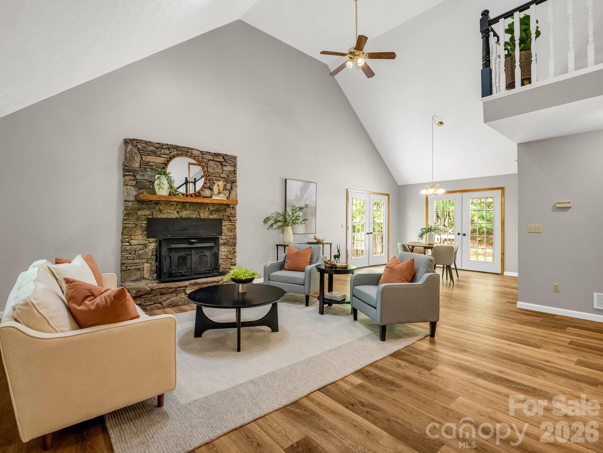 Vaulted ceilings and stone fireplace with wood stove in living room - 2304 Mountain Page Road, Saluda
